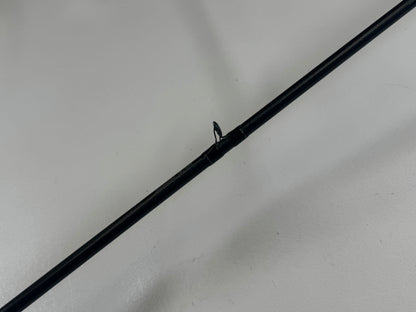 Close-up of a Daiwa Zillion 7'3" heavy used casting rod, black against a light gray backdrop. The focus is on a guide ring, showcasing its excellent condition—perfect for those interested in quality used gear and our Rod and Reel Trade-In Program.