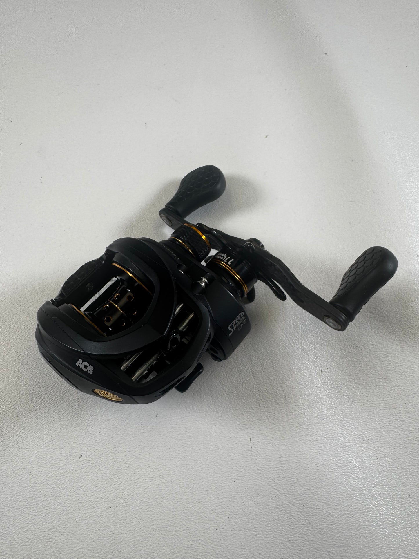 The Lew's Tournament Pro TP1SHLA 7.5:1 used casting reel in excellent condition features gold accents, textured handle grips, and multiple adjustment knobs. Trade in your gear for store credit with our Rod and Reel Trade-In program!.