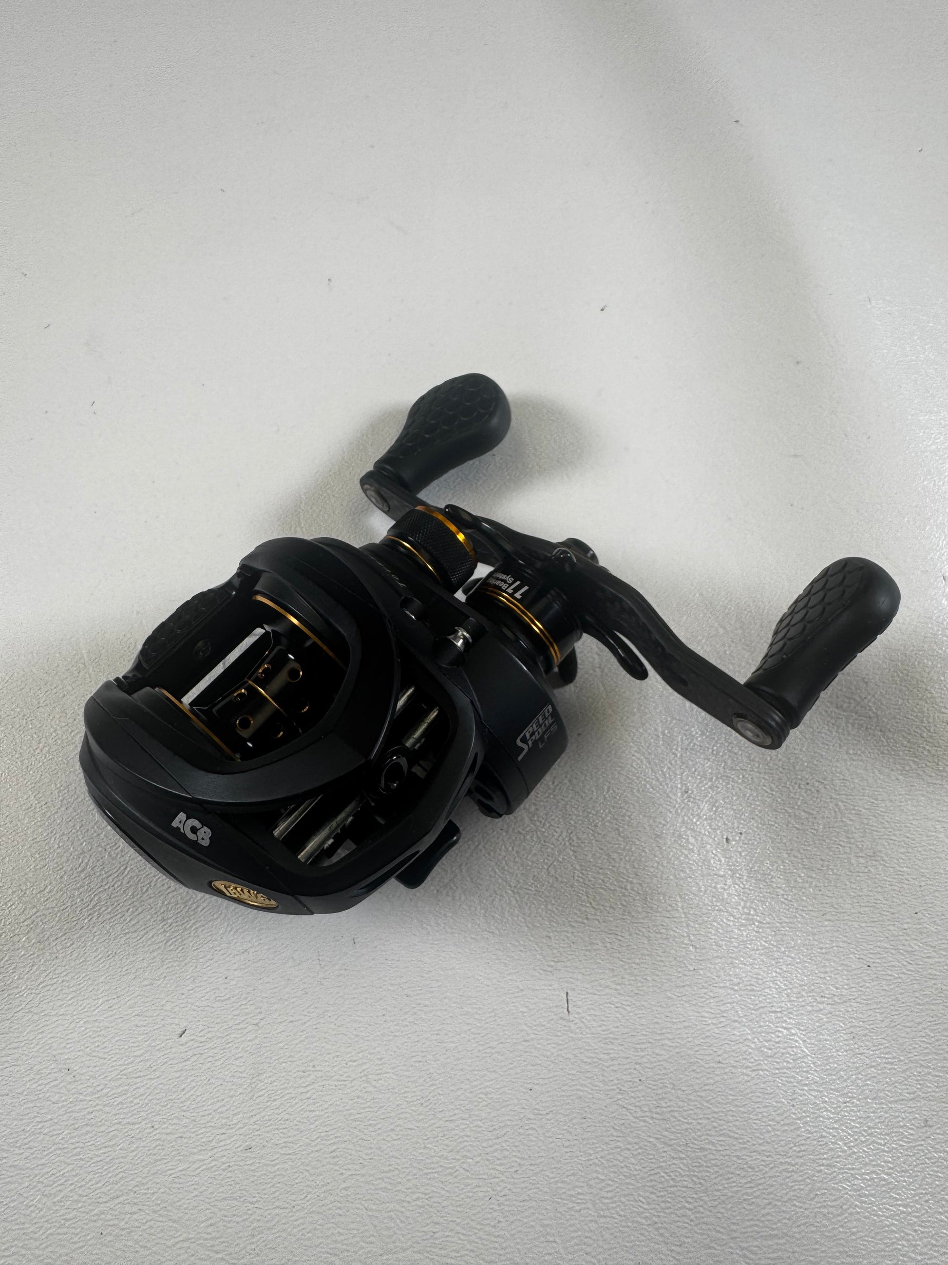 The Lew's Tournament Pro TP1SHLA 7.5:1 used casting reel in excellent condition features gold accents, textured handle grips, and multiple adjustment knobs. Trade in your gear for store credit with our Rod and Reel Trade-In program!.