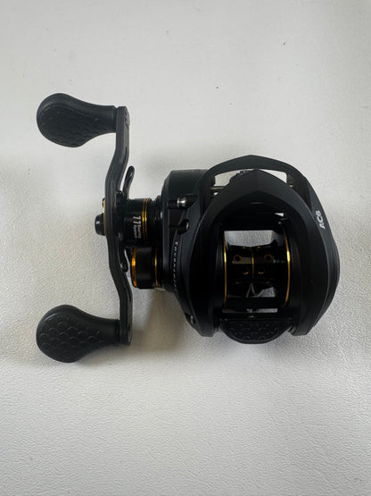 A Lew's Tournament Pro TP1SHLA 7.5:1 gear ratio baitcasting reel in excellent condition, with dual textured handles and gold accents, rests on a white surface—an ideal upgrade through our Rod and Reel Trade-In program.