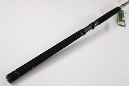 A close-up of the St. Croix Mojo Musky Trolling MMT90HM2 9'0" Heavy – a used casting rod in mint condition with a black foam grip, metal reel seat, and green tag, ideal for our Rod and Reel Trade-In Program. Plain white background.