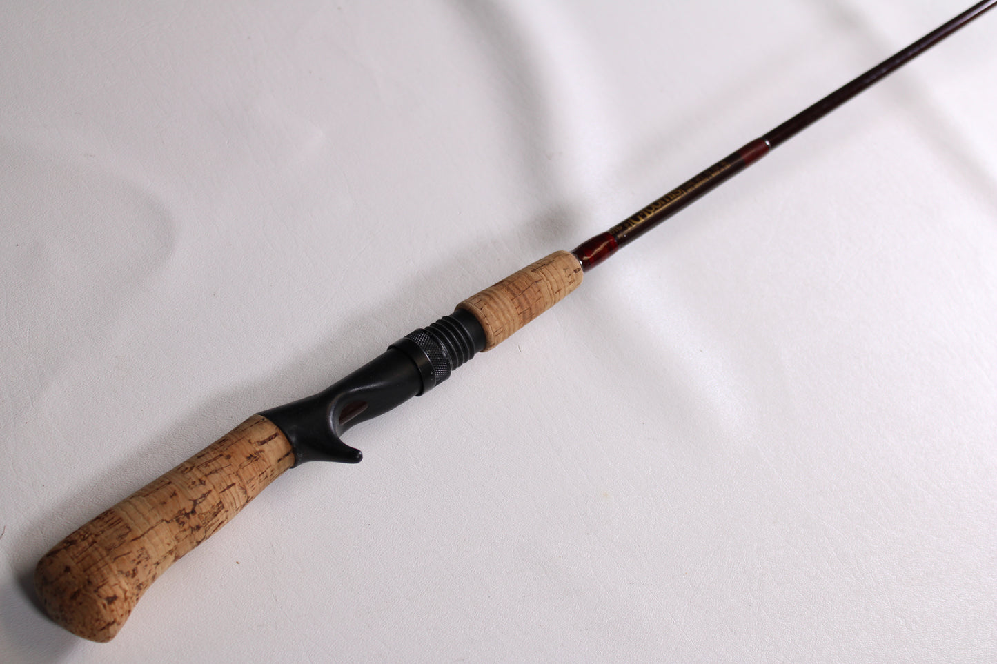 A G. Loomis IM6 CR 664C 5'6" Heavy - Used Casting Rod in good condition, shown diagonally on a white surface—ideal for anglers seeking quality used G. Loomis gear or considering our rod and reel trade-in for store credit.