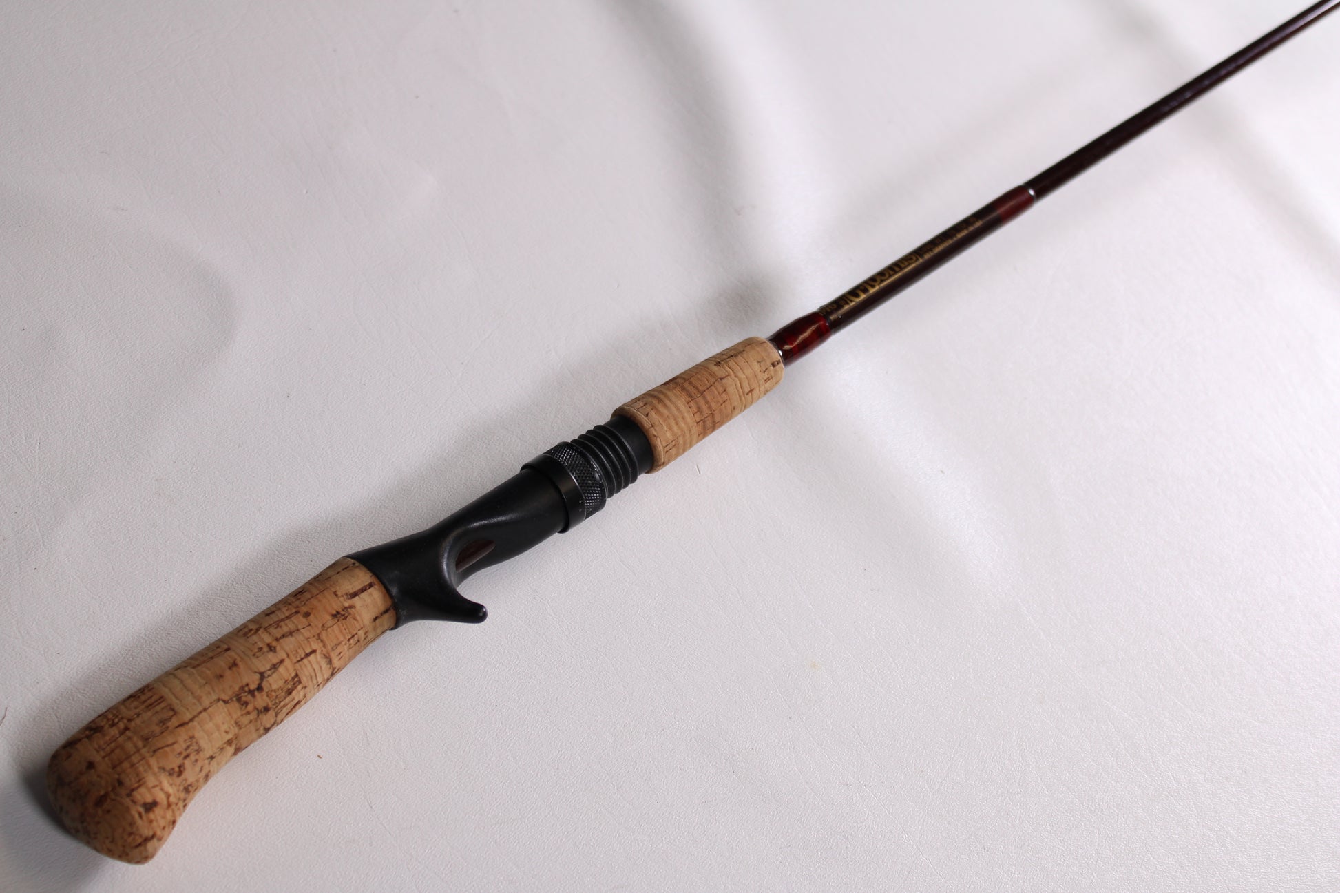 A G. Loomis IM6 CR 664C 5'6" Heavy - Used Casting Rod in good condition, shown diagonally on a white surface—ideal for anglers seeking quality used G. Loomis gear or considering our rod and reel trade-in for store credit.