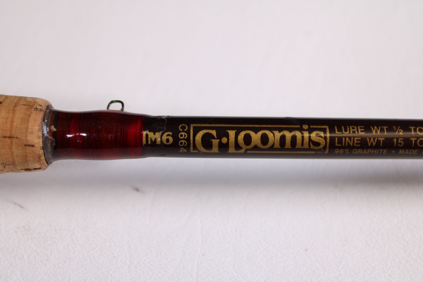 Close-up of a G. Loomis IM6 CR 664C 5'6" Heavy used casting rod in good condition, with gold specs for lure and line weight. Ideal for anglers—trade in your old gear for store credit! Handle partially visible on the left.