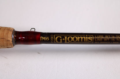 Close-up of a G. Loomis IM6 CR 664C 5'6" Heavy used casting rod in good condition, with gold specs for lure and line weight. Ideal for anglers—trade in your old gear for store credit! Handle partially visible on the left.