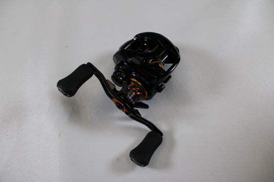 A Daiwa Morethan PE1000XH-TW 8.6:1 used baitcasting reel in excellent condition, featuring dual-padded handles, is displayed on a plain white surface—perfect for store credit during our Rod and Reel Trade-In.