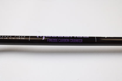 A close-up of the St. Croix Mojo Bass JOC72MHMF Finesse Carbon Cranker 7'2" Medium Heavy Used Casting Rod in excellent condition, with "FINESSE CARBON CRANKER" in purple—ideal for upgrading via our Rod and Reel Trade-In Program.