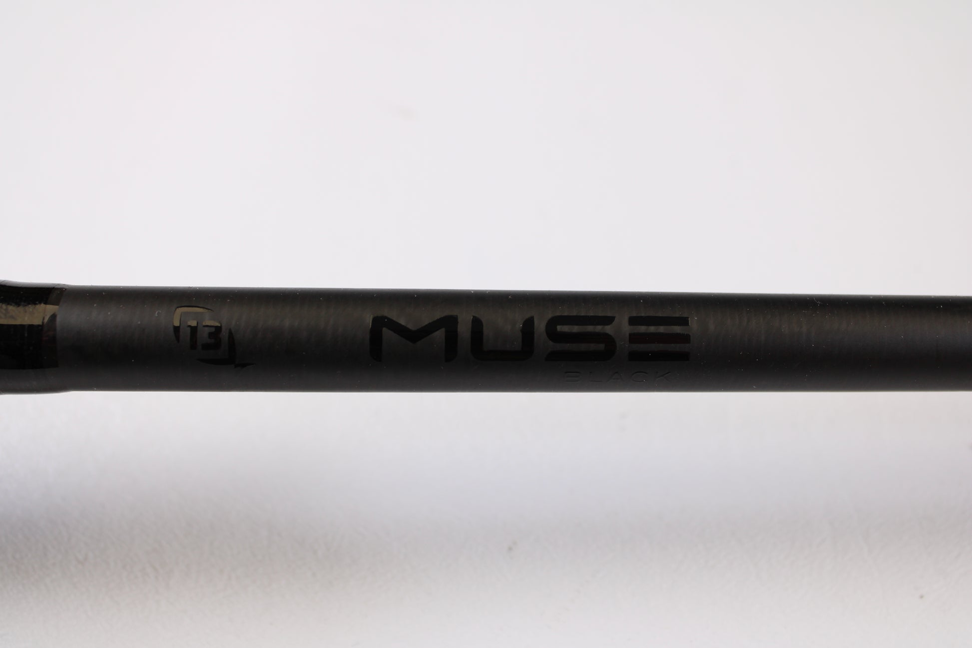 A close-up of a black 13 Fishing Muse 7'6" Medium Heavy used casting rod in excellent condition, with "MUSE" and "ENVE" visible and a small "13" logo on the left. Ideal for those seeking used gear or interested in our rod and reel trade-in program. Plain white background.