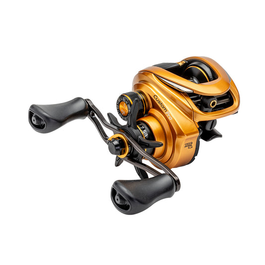 The Lew's Custom Pro Gen 3 Casting Reel 7.5:1 RH (CPB1SHG3) features a gold and black design, dual handles, Inertia Transfer Braking, and a tension adjustment knob, shown on a white background.