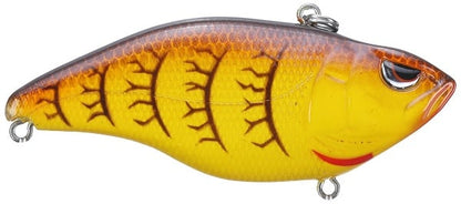 The SPRO Aruku Shad Lipless Crankbait features vibrant yellow and orange scales with detailed eye and fin patterns. Outfitted with Gamakatsu treble hooks on top and bottom, it ensures secure attachment to your fishing line.
