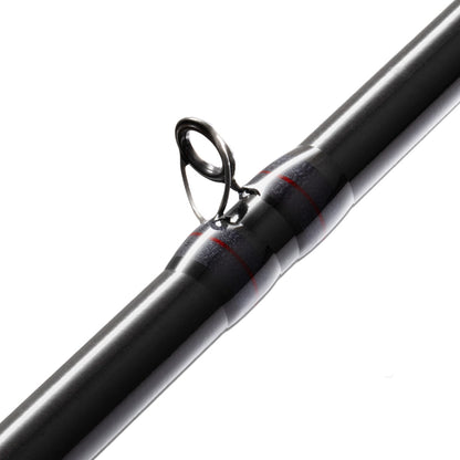 Close-up of the sleek St. Croix Victory Casting Rod 7'2" Heavy Rip'n Chatter | VTC72HM with a metal guide and visible thread wraps highlighting its hybrid carbon fiber construction. Its shiny finish beautifully contrasts against the white background.