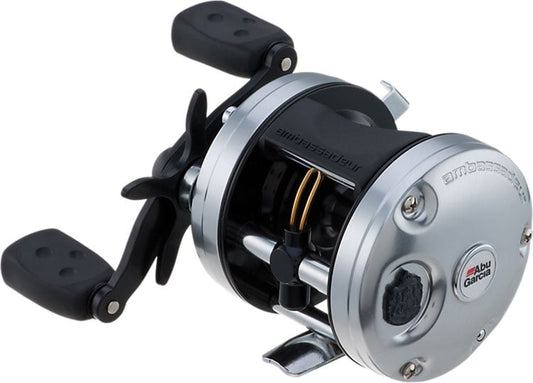 The Abu Garcia Ambassadeur C3 5.3:1 Casting Reel 6500 features a round silver and black body, dual handles, visible gears, and a Carbon Matrix Drag System, designed for attachment to a fishing rod.