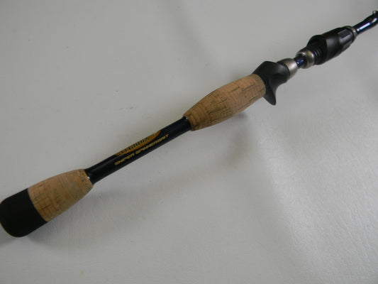 A close-up of the St. Croix Legend Tournament Bass TBC69MHMF Sniper Spinnerbait 6'9" Medium Heavy Used Casting Rod handle with cork grips and black reel seat—ideal for those considering our Rod and Reel Trade-In Program for store credit.