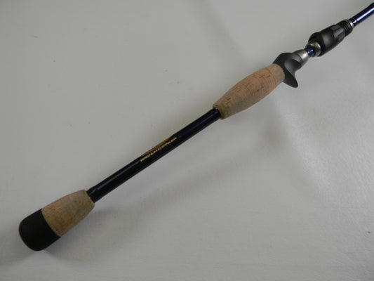 A close-up of the St. Croix Legend Tournament Bass TBC710HM Magnum Cranker 7'10" Heavy casting rod with cork grips and a black finish—an excellent used option for anglers or those joining our Rod and Reel Trade-In Program.