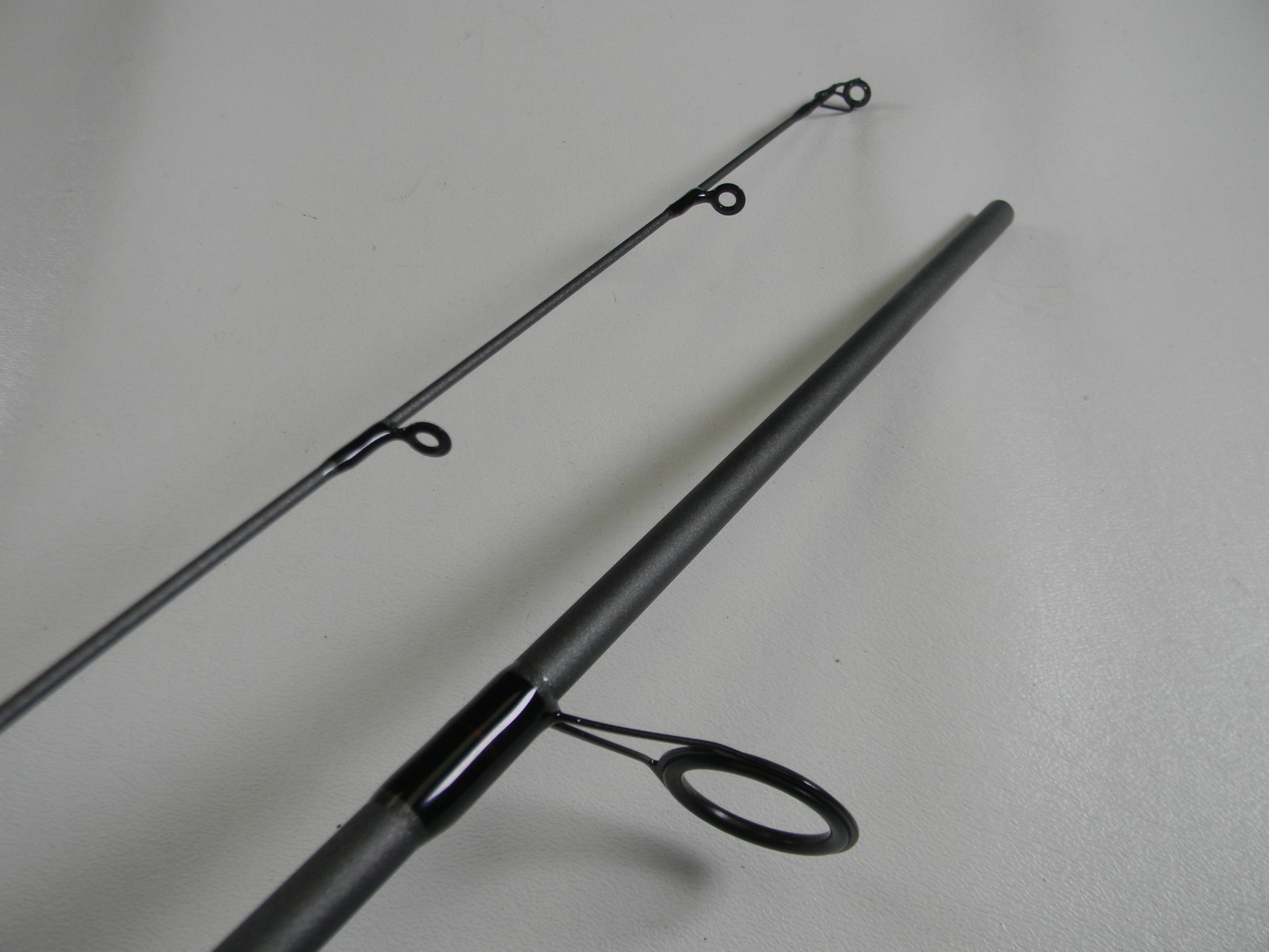 Close-up of a St. Croix X Trek CTCS70MF2-C 7'0" Medium used spinning rod in excellent condition, shown separated to highlight its black line guides and smooth finish—ideal for our Rod and Reel Trade-In Program or store credit.