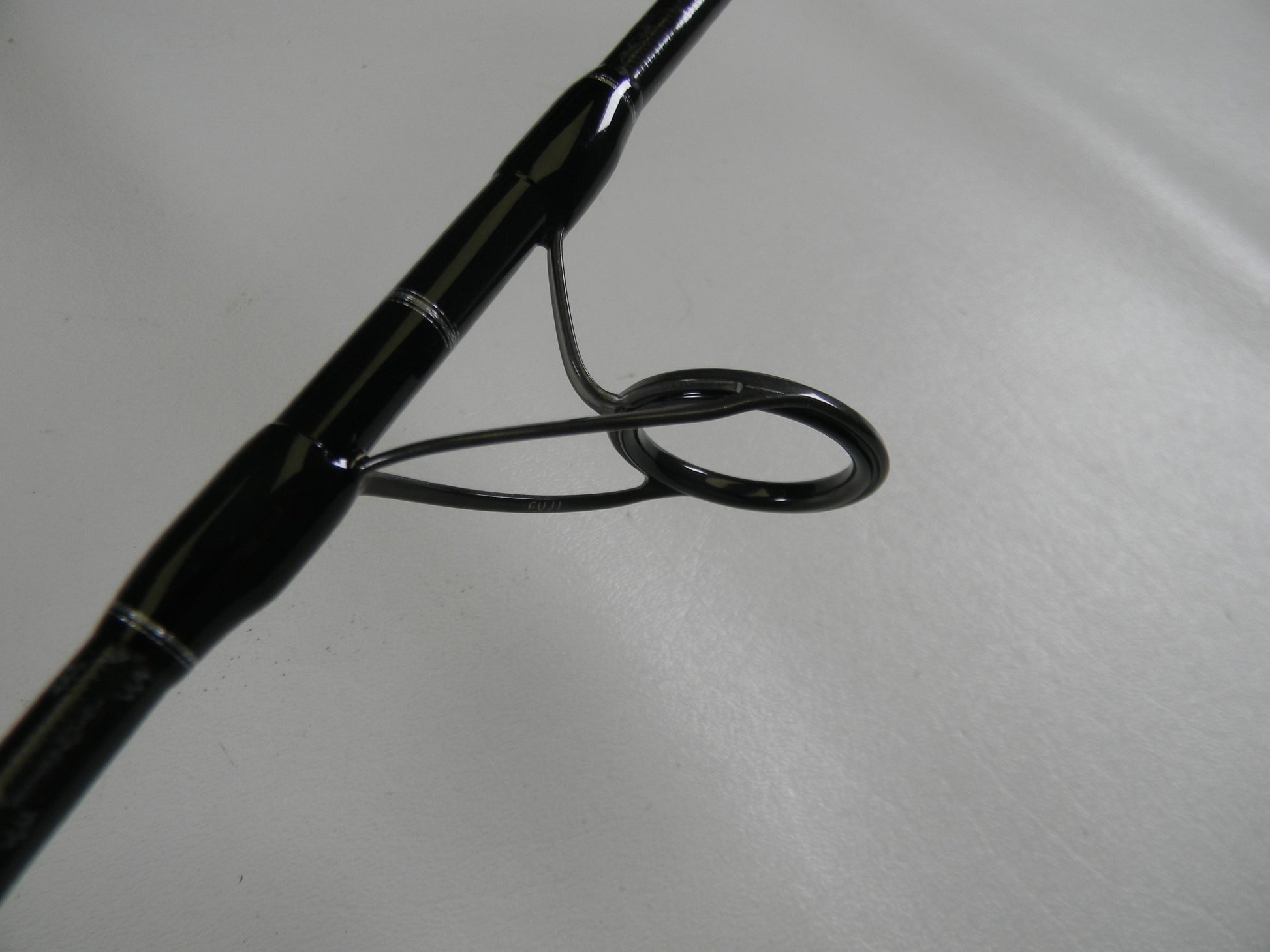 A close-up of a Shimano Grappler Type C GRPCS70L 7'0" Light Used Spinning Rod guide, showing the ring and frame—ideal for those exploring used Shimano rods or our Rod and Reel Trade-In Program for store credit.