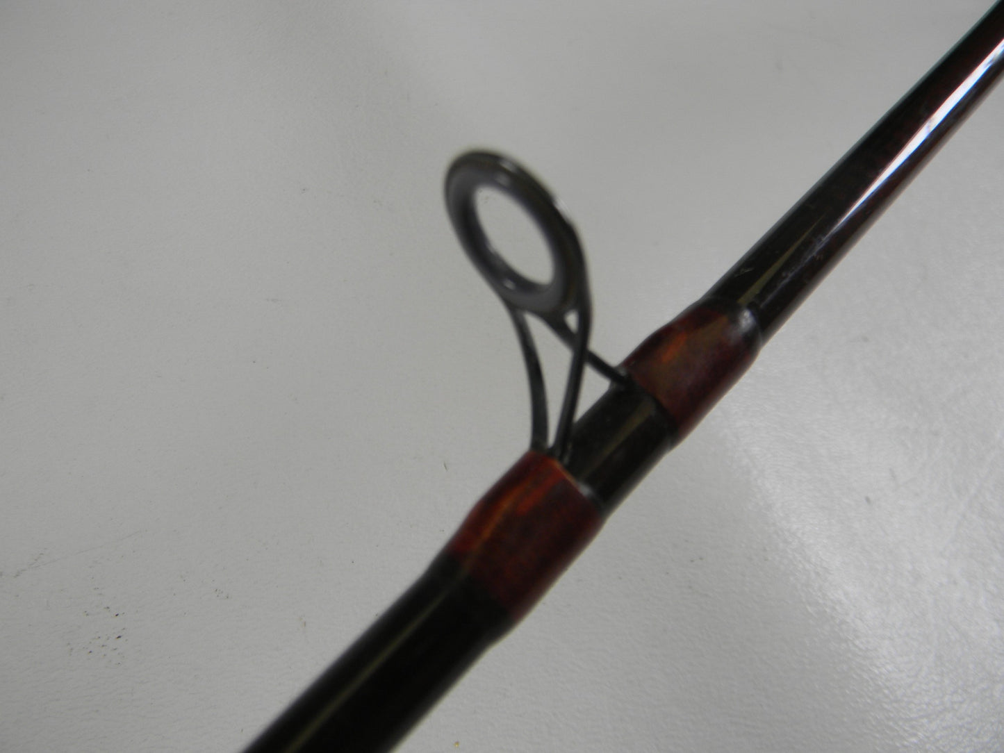 Close-up of the metal guide ring on a G. Loomis Custom Pistol Grip CR664 IM6 5'6" Heavy Used Casting Rod (Fair Condition) against a plain background—ideal for anyone interested in our Rod and Reel Trade-In Program.