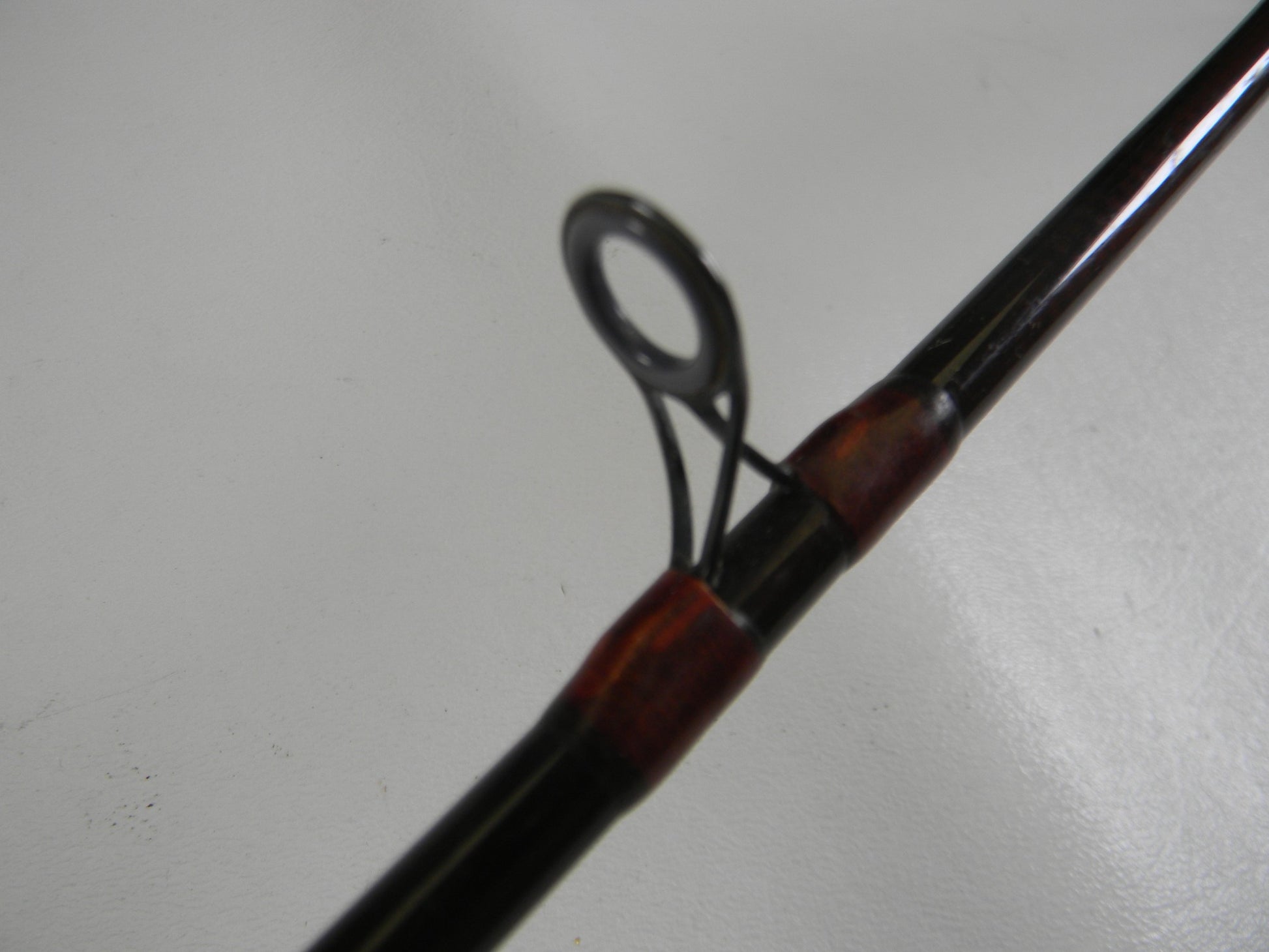 Close-up of the metal guide ring on a G. Loomis Custom Pistol Grip CR664 IM6 5'6" Heavy Used Casting Rod (Fair Condition) against a plain background—ideal for anyone interested in our Rod and Reel Trade-In Program.