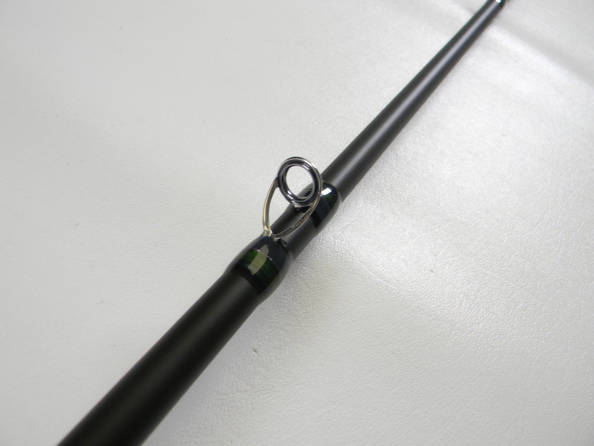 Close-up of a Megabass Orochi X10 F7-71XT Swamp Survivor 7'1" Heavy Used Casting Rod in excellent condition, highlighting its metal line guide—ideal for those seeking top-quality, pre-owned Megabass fishing gear.