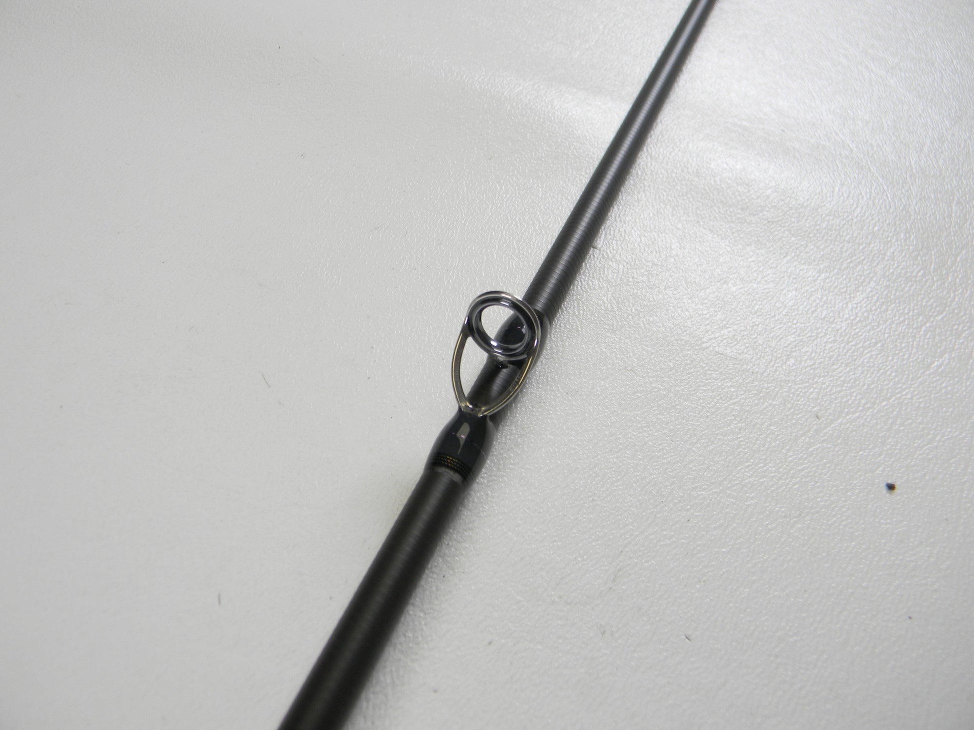 Close-up of a Megabass Destroyer P5 F4-65X OneTen Stick 6'5" Medium Used Casting Rod in excellent condition, highlighting its metal line guide—ideal for upgrading your gear or trading in with our store credit program.