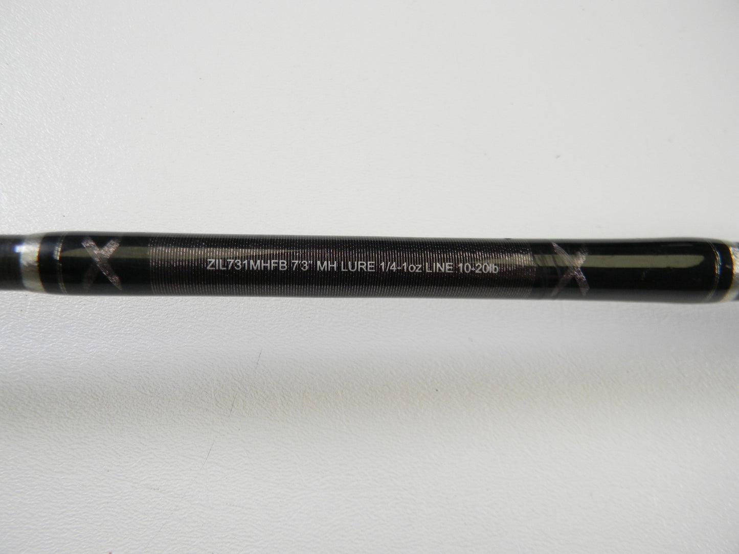 A close-up of a Daiwa Zillion ZIL731MHFB 7'3" MH used casting rod in excellent condition, displaying specs in white text on a plain background—ideal for upgrading with our Rod and Reel Trade-In Program.