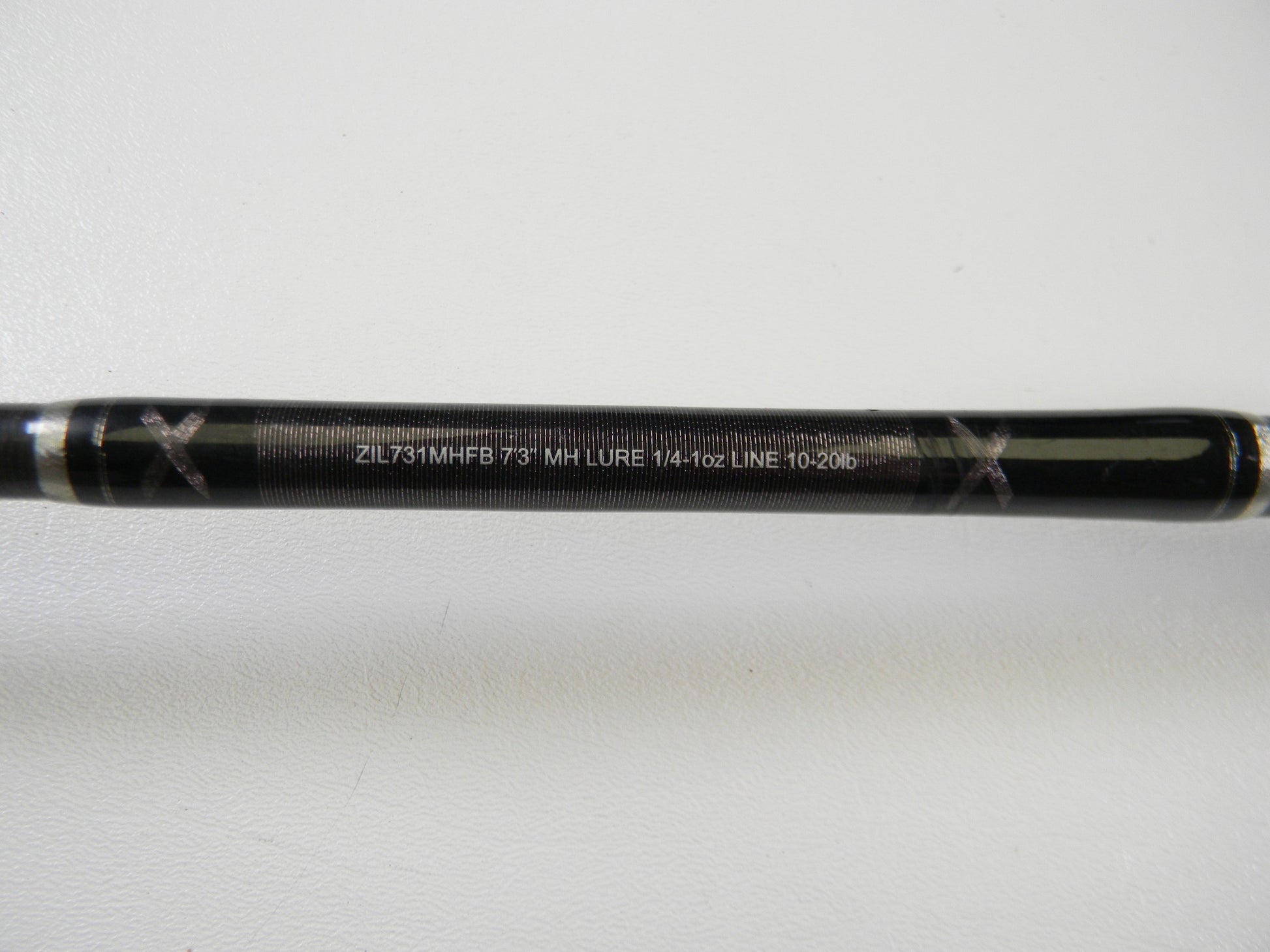 A close-up of a Daiwa Zillion ZIL731MHFB 7'3" MH used casting rod in excellent condition, displaying specs in white text on a plain background—ideal for upgrading with our Rod and Reel Trade-In Program.