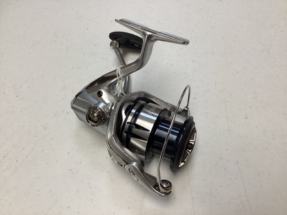 A Shimano Stradic FL ST4000XGFL Used Spinning Reel in very good condition, shown on a white speckled surface, is perfect for our Rod and Reel Trade-In Program—trade in your used Shimano gear for store credit.