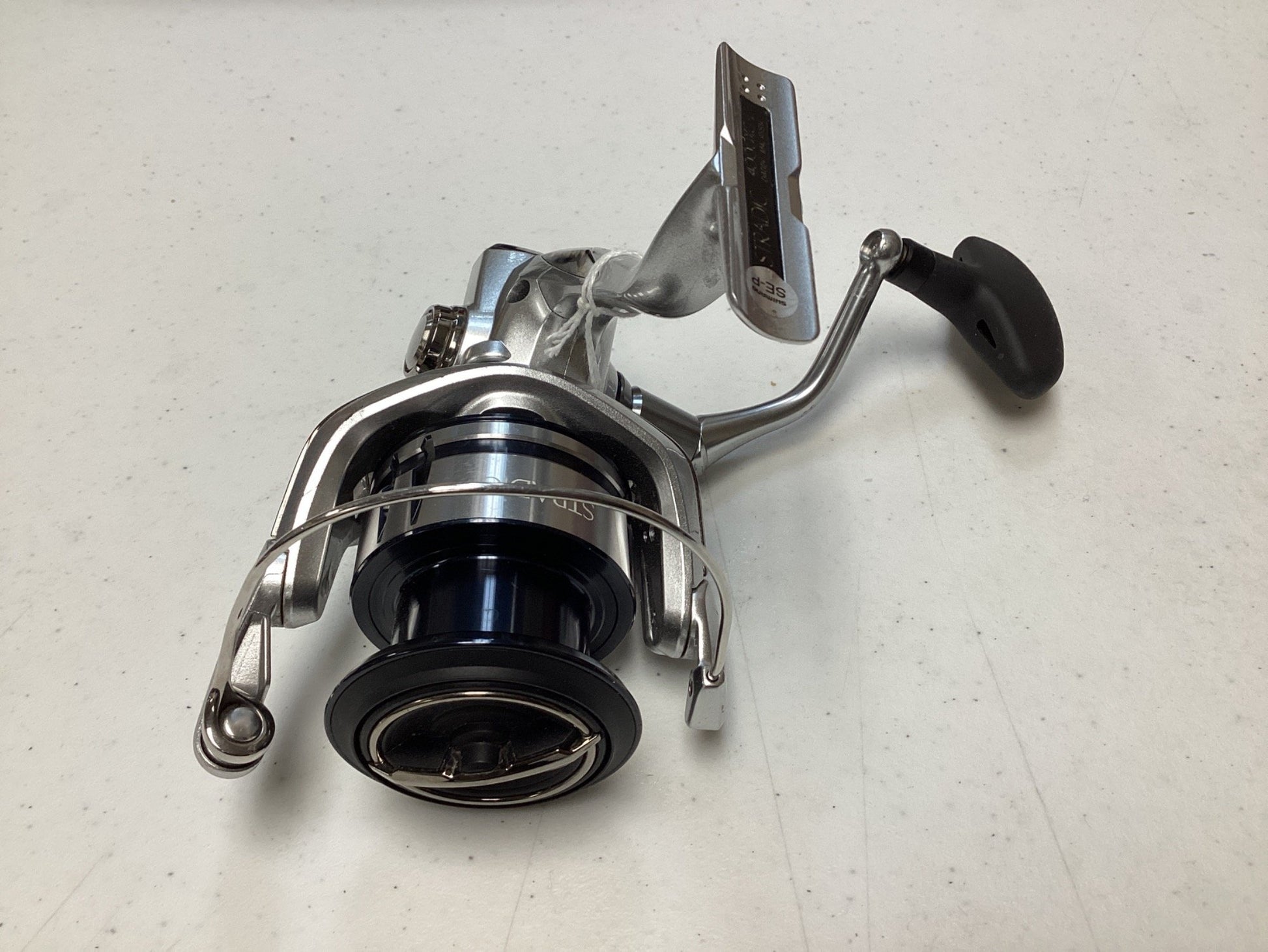 A close-up of a Shimano Stradic FL ST4000XGFL Used Spinning Reel in very good condition, featuring a metallic finish and black spool—ideal for anglers trading in gear for store credit via our Rod and Reel Trade-In Program.