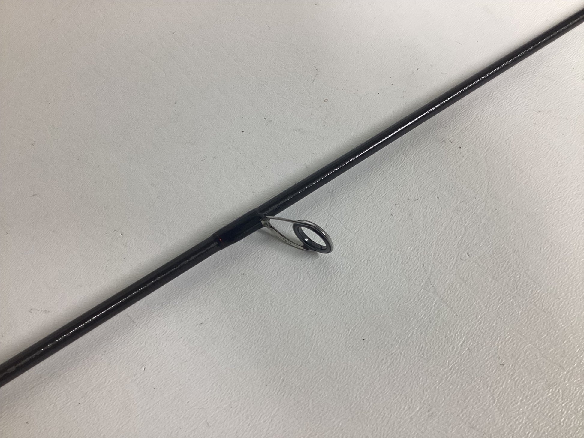 A close-up of the Shimano Poison Adrena PAD267MLA 6'7" Medium Light used spinning rod in excellent condition, showing a metal line guide—great for fishing fans or those trading in gear for store credit.