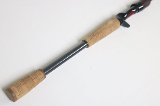A close-up of a Daiwa Steez STAGS721HFB 7'2" Heavy Used Casting Rod in very good condition, featuring a cork handle and metal shaft—perfect for anglers seeking quality used gear or considering a rod trade-in.