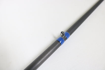 A close-up of the Alpha Angler Mag-Hitter 7'11" Magnum Heavy Used Casting Rod in excellent condition shows a blue-wrapped guide ring on a black rod—ideal for those interested in our rod and reel trade-in program for store credit.