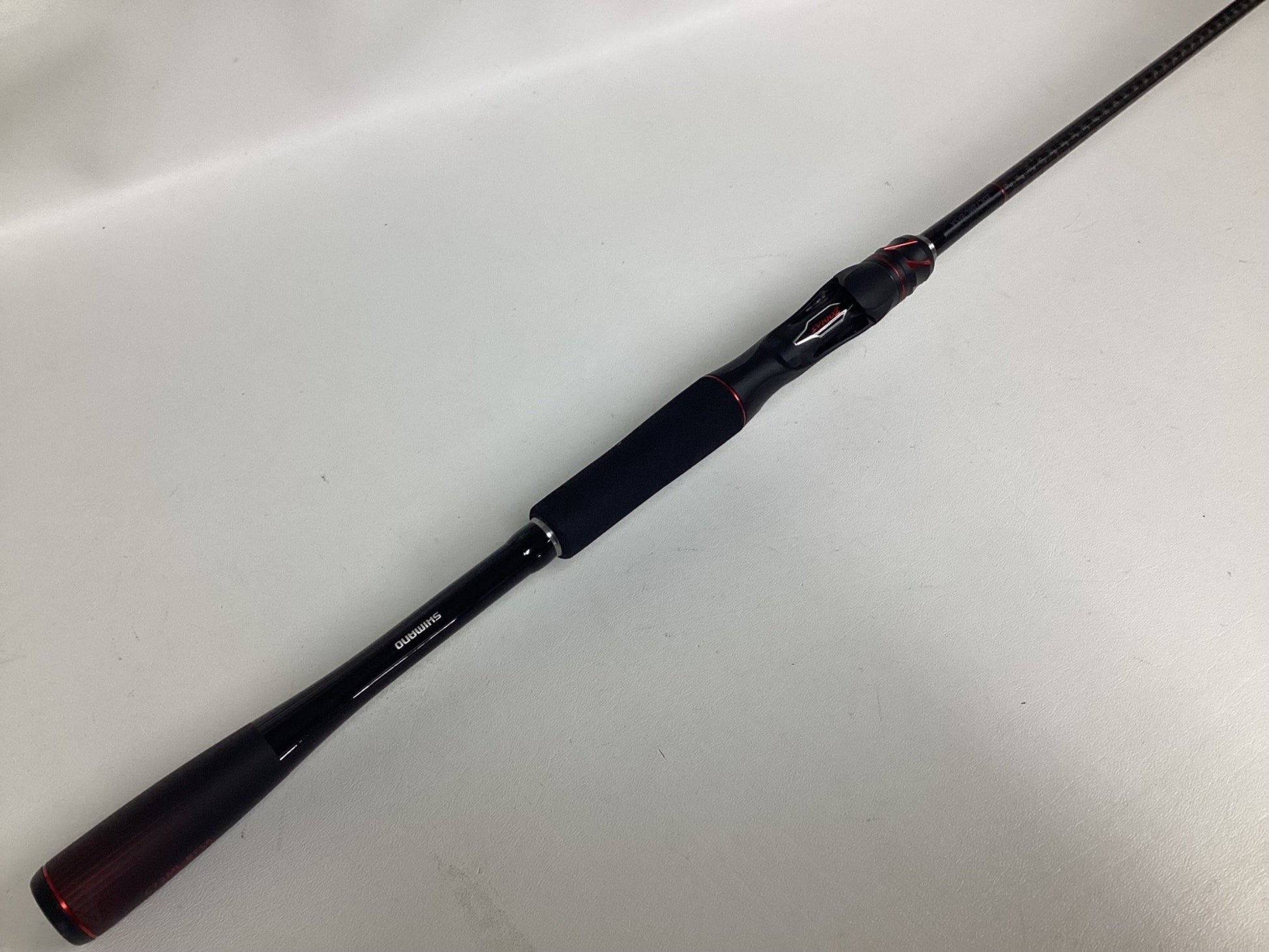 A Shimano Zodias ZDC72MLBFSA used casting rod in excellent condition, black with red accents and a foam handle, displayed diagonally on a plain white surface.