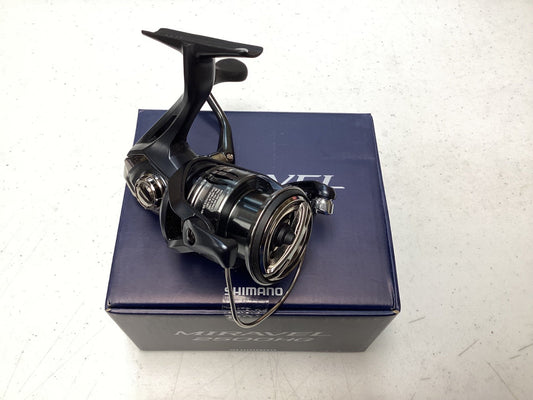 A Shimano Miravel MIR2500HG Used Spinning Reel in excellent condition is shown on a blue Shimano box, set on a white surface.
