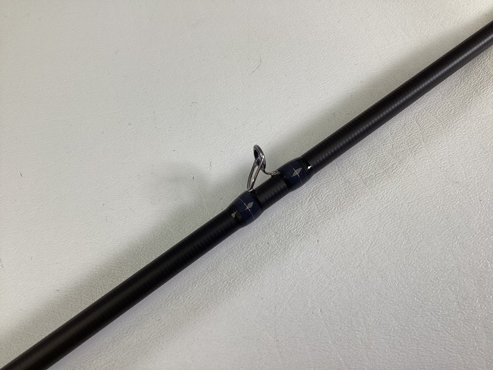 A close-up of the Megabass Destroyer P5 F3.1/2-70X Used Casting Rod in excellent condition, highlighting one of its line guides against a plain white background.