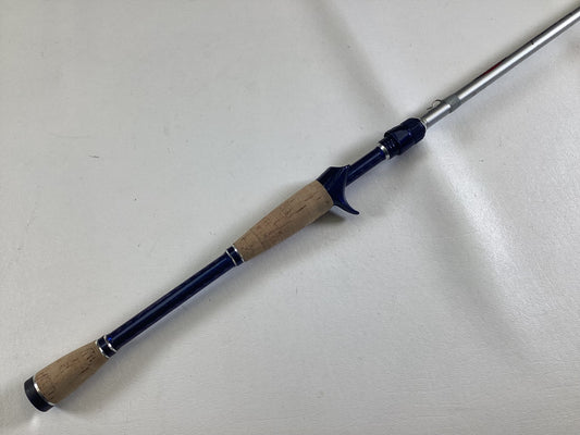 The Duckett Jacob Wheeler Select DFWS73M-CC 7'3" Medium Crankin - Used Casting Rod, in excellent condition, features a cork handle and dark blue accents—ideal for our Used Gear or Rod and Reel Trade-In Program.