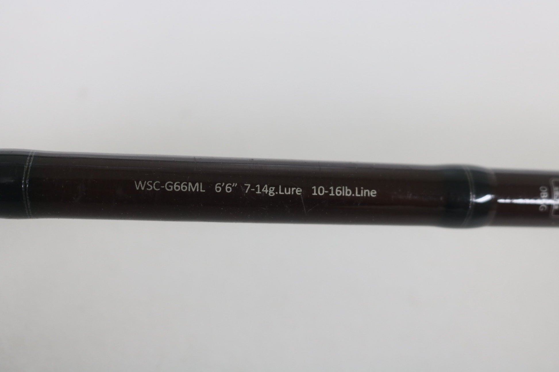 A close-up of the Legit Design Wild Side WSC-G66ML 6'6" Medium Light Used Casting Rod shows its specs in white on the dark shaft. Upgrade your rod with this Legit Design option through our Rod and Reel Trade-In Program.