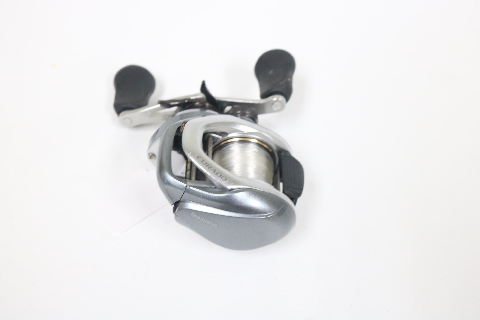 Shimano Curado I 200PG 5.5:1 Used Casting Reel in excellent condition, with black handle grips, shown on a white background. Eligible for Rod and Reel Trade-In—get store credit when you upgrade your used gear!.