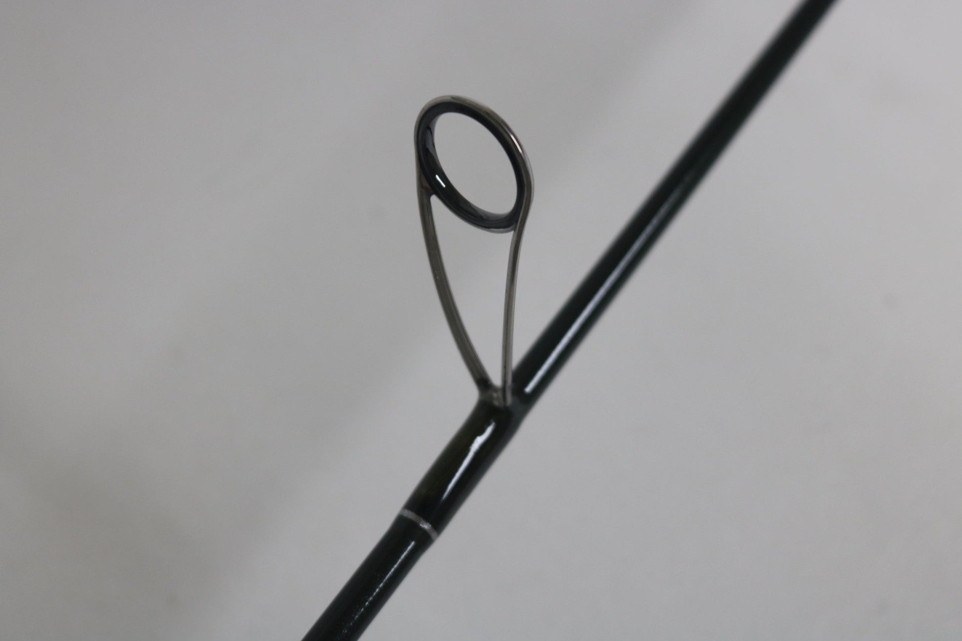 Close-up of a St. Croix Legend Elite ES60MLF 6'0" Medium Light used spinning rod guide—metal ring and support visible, ideal for those interested in upgrading with our Rod and Reel Trade-In Program. Mint condition from St. Croix.