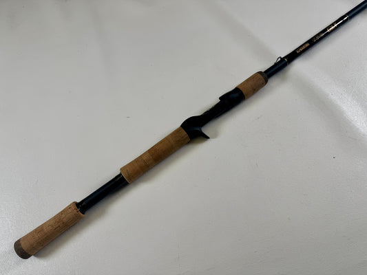 The G. Loomis 24 GLX 954c FPR 7'11" Heavy Used Casting Rod in excellent condition is shown diagonally on a light surface—an ideal choice for those interested in our Rod and Reel Trade-In Program to earn store credit.