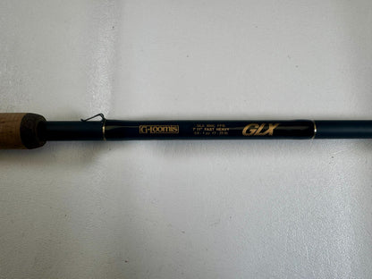 A close-up of the G. Loomis 24 GLX 954c FPR 7'11" Heavy Used Casting Rod in excellent condition, showing gold model details on a dark rod with a cork handle—ideal for those interested in used gear or our Trade-In Program.