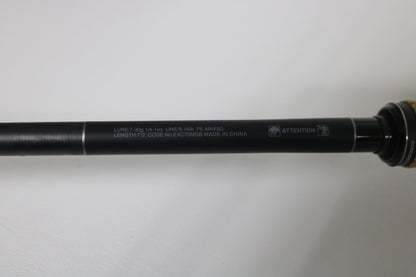 A close-up of a Shimano Expride B EXC70MGB Used Casting Rod in excellent condition, showing white specs like lure weight, line rating, length, code, and "Made in China," with part of the wooden handle on the right.