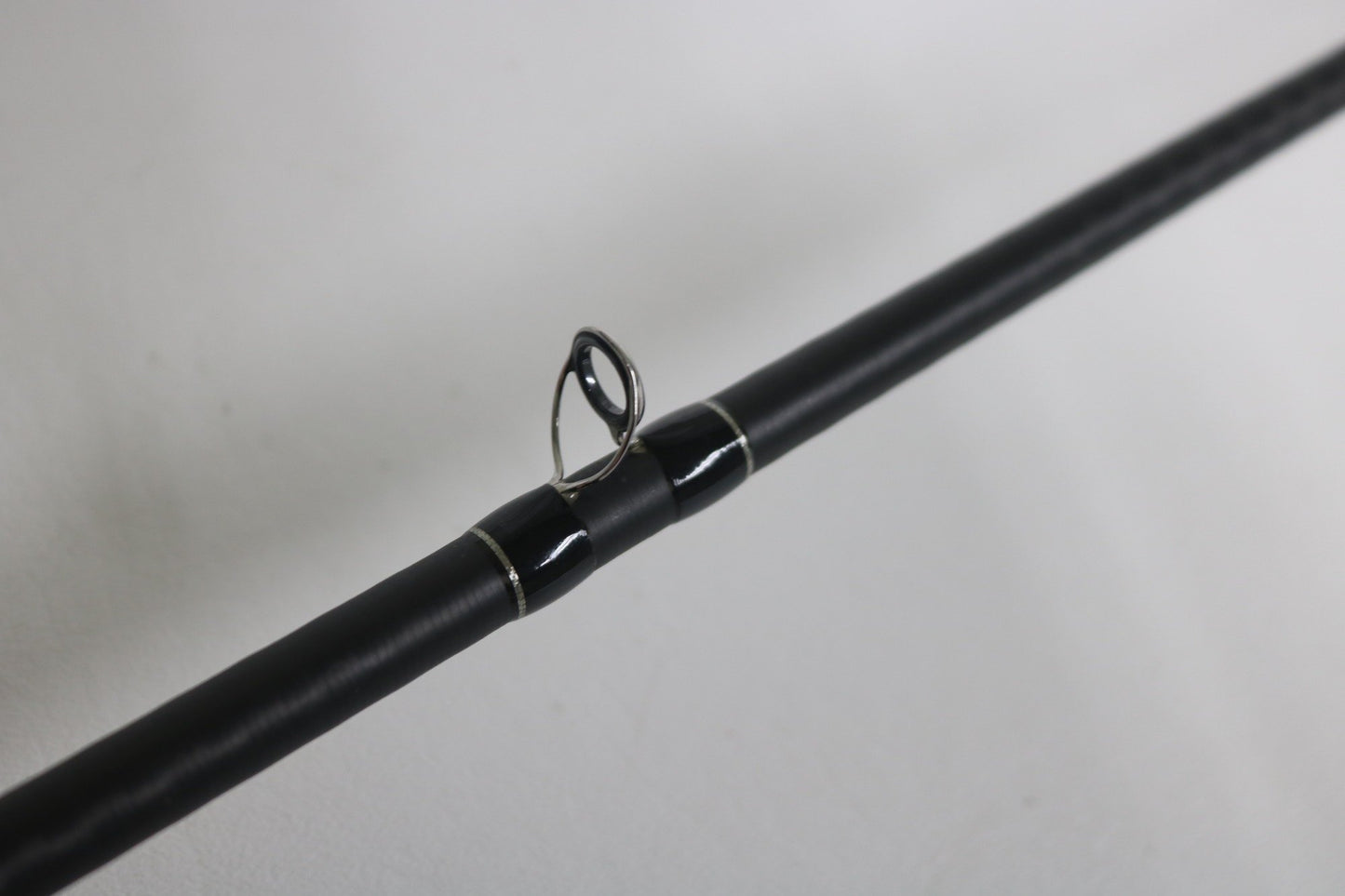 A close-up of the Shimano Expride B EXC70MGB Used Casting Rod in excellent condition, highlighting one of its metal line guides against a plain white background.