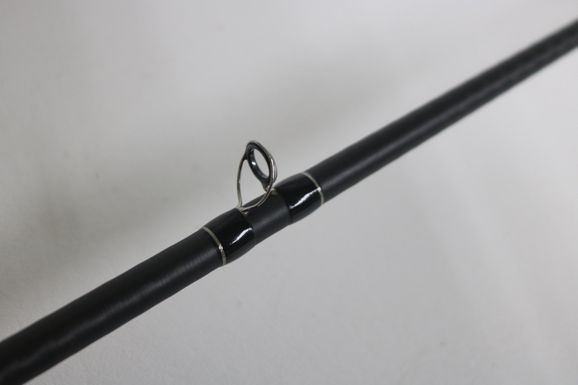 A close-up of the Shimano Expride B EXC70MGB Used Casting Rod in excellent condition, highlighting one of its metal line guides against a plain white background.