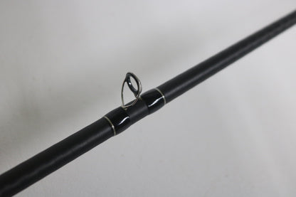 A close-up of the Shimano Expride B EXC70MGB Used Casting Rod in excellent condition, highlighting one of its metal line guides against a plain white background.