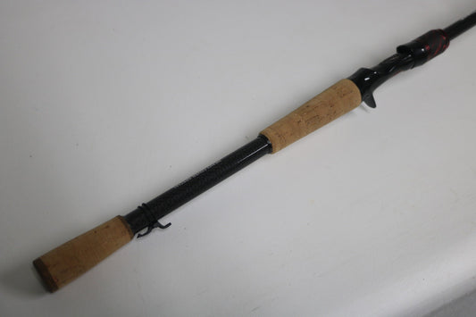A Daiwa Steez AGS STAGS741XHFB used casting rod in excellent condition, featuring a cork handle and black reel seat, is shown resting on a white surface.