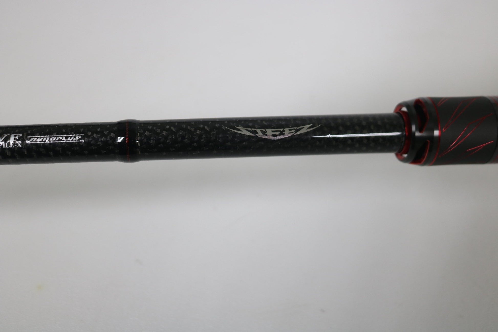 A close-up of the Daiwa Steez AGS STAGS741XHFB casting rod in excellent used condition, featuring black carbon fiber with red accents and "Steez" branding, set against a plain white background.