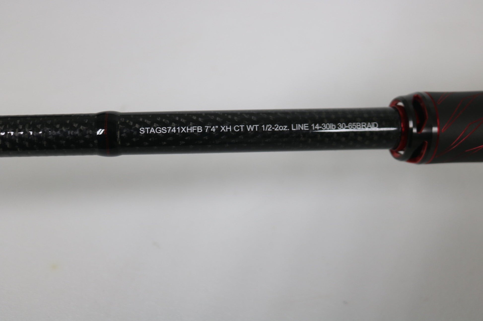 A close-up of a Daiwa Steez AGS STAGS741XHFB casting rod (used, excellent condition) shows black with red accents and white text listing: 7'4" XH CT WT 1/2-2oz. LINE 14-30lb, 30-65BRAID.