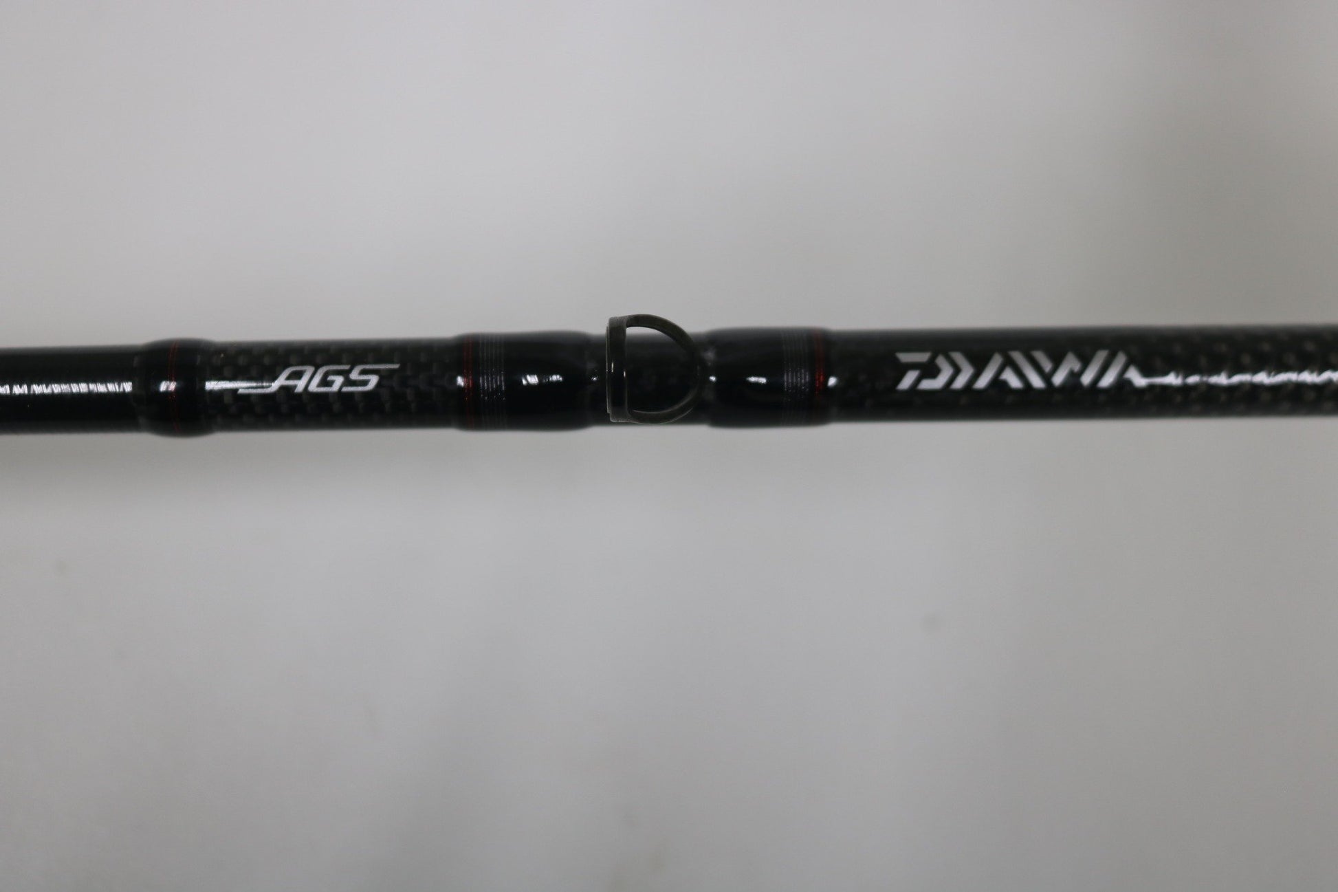 Close-up of the Daiwa Steez AGS STAGS741XHFB Used Casting Rod in excellent condition, showing "AGS" and "DAIWA" in white on carbon fiber, set against a plain light background.