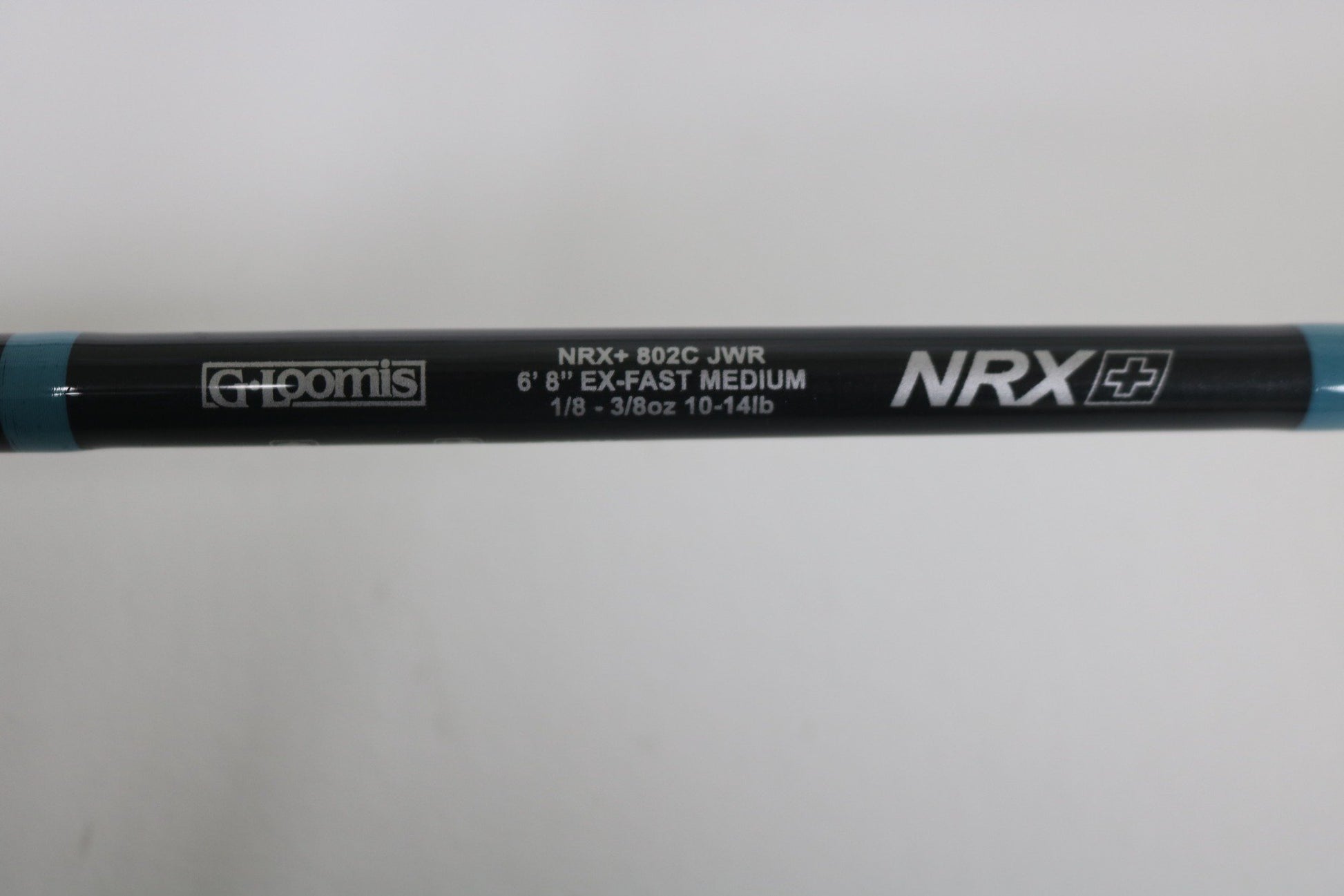 Close-up of the G. Loomis NRX+ 802C JWR Used Casting Rod in excellent condition, featuring its specs on a black background with blue accents—ideal for upgrading via our Rod and Reel Trade-In Program.