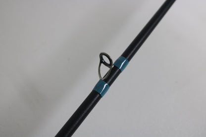 A close-up of the G. Loomis NRX+ 802C JWR Used Casting Rod in excellent condition shows a single metal guide ring with blue wrappings—an ideal choice for those trading up through our Rod and Reel Trade-In Program.
